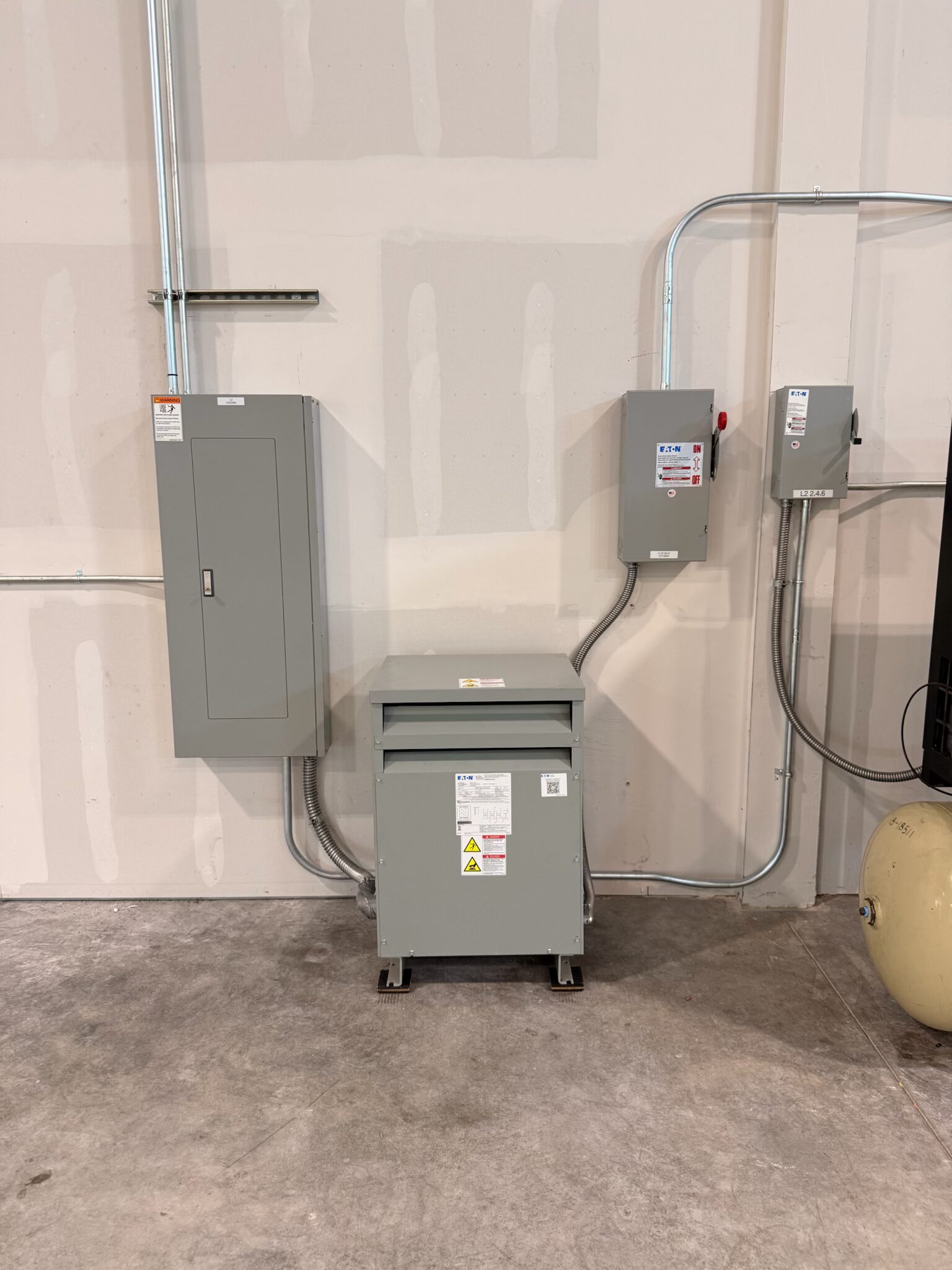 45kVA transformer, 125A Eaton distribution panel, and safety disconnect mounted on commercial warehouse wall — Cyber Electric LLC