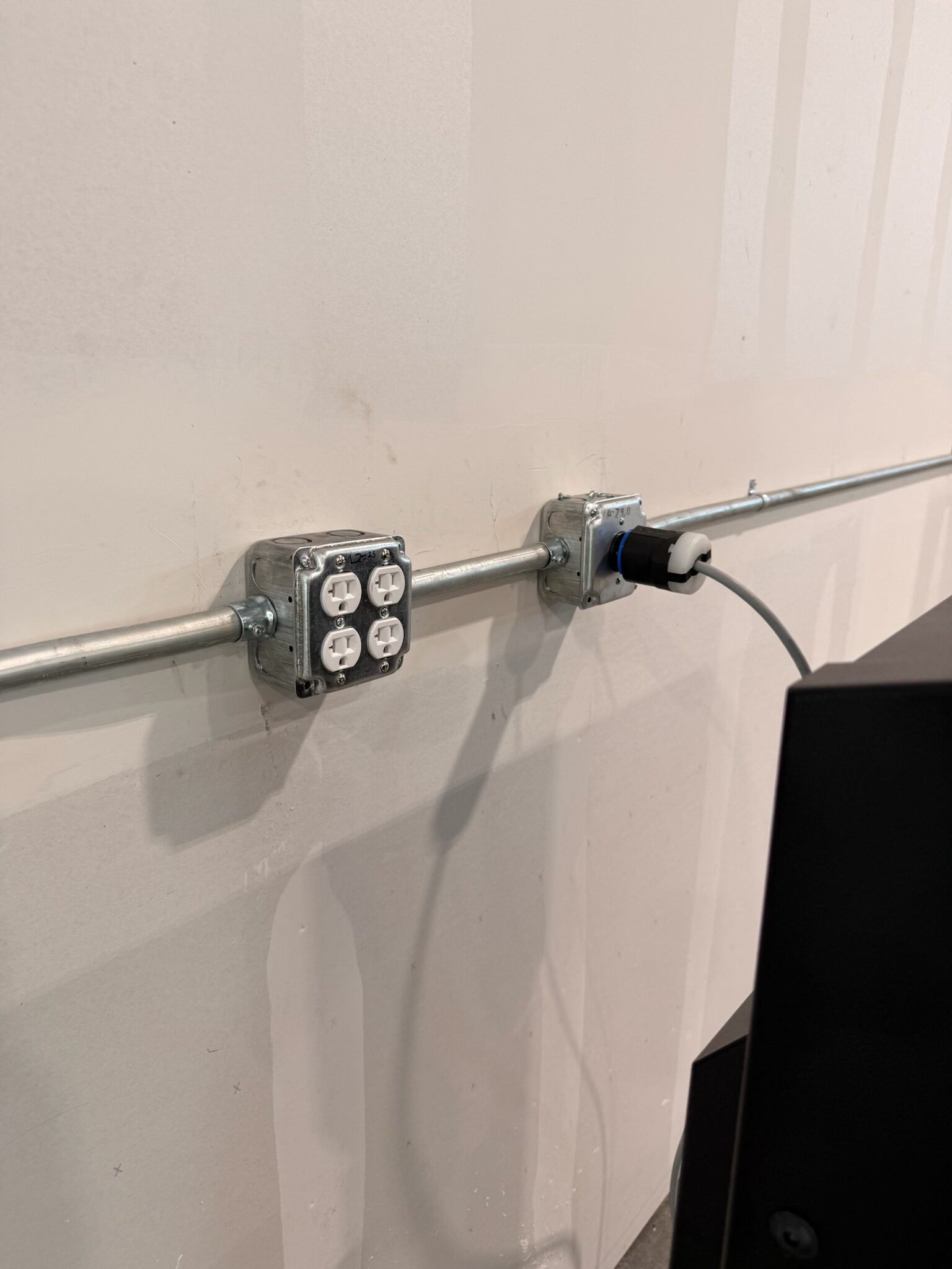 Conduit with duplex outlet boxes and liquid-tight connector feeding fabrication equipment — Cyber Electric LLC
