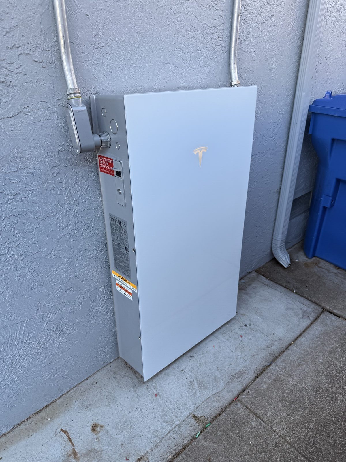 Tesla Powerwall 3 side angle showing conduit runs and rapid shutdown switch — Cyber Electric LLC