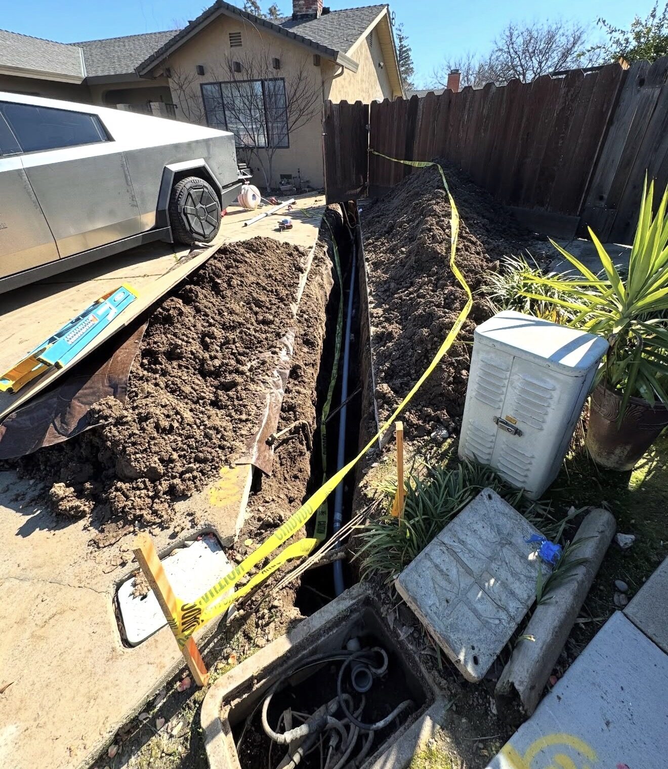 Underground feeder trench excavated along side of house with conduit laid in — Cyber Electric LLC