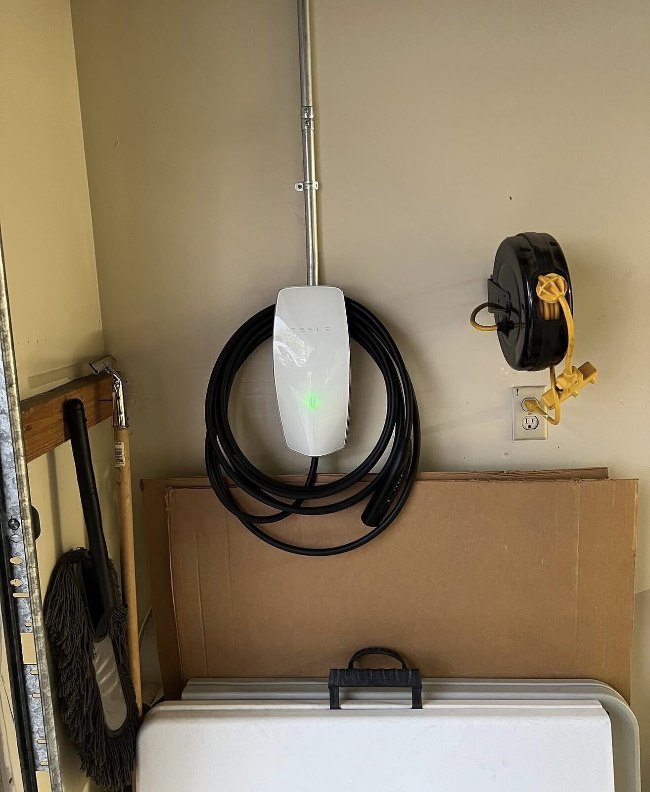 Tesla Wall Connector on drywall garage wall with EMT conduit running up from below — Cyber Electric LLC