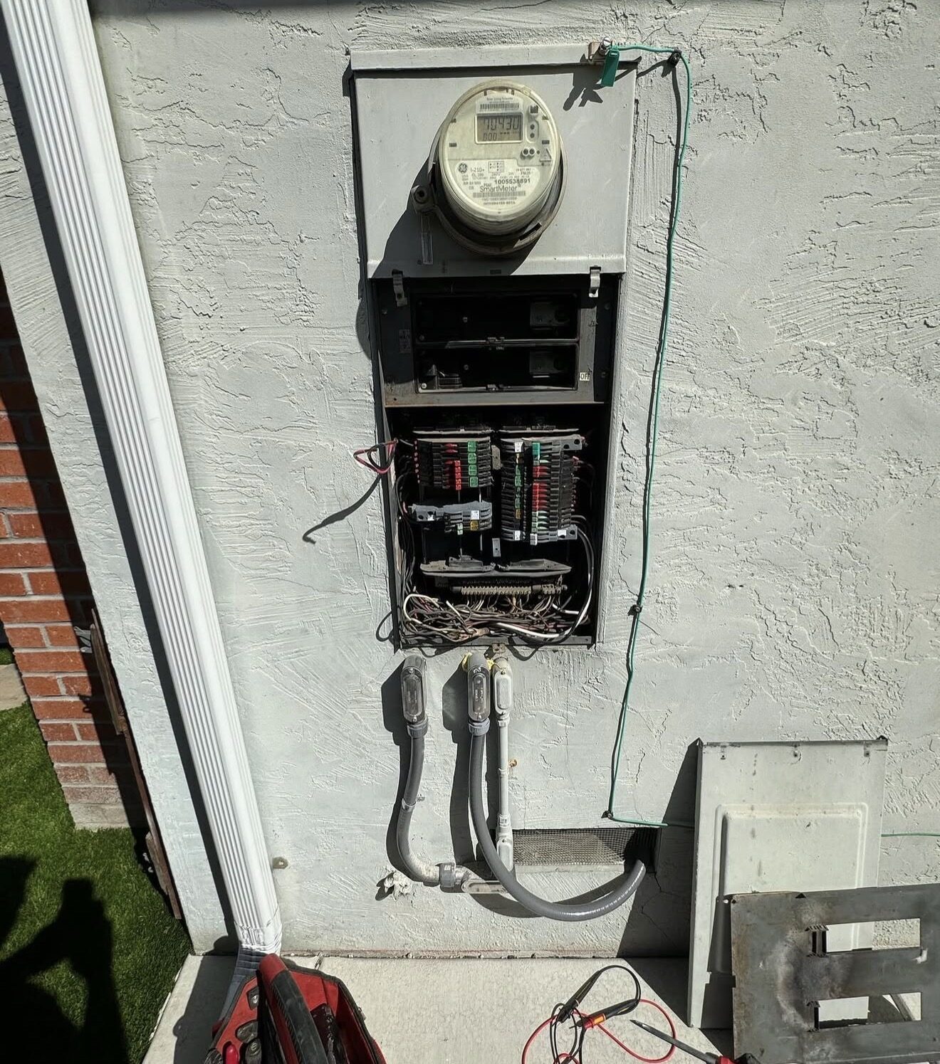 Old Zinsco 200A panel before replacement — multiple flex conduit entries hanging from bottom — Cyber Electric LLC